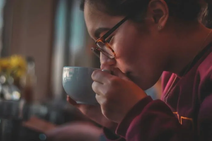 コーヒーの香りを嗅いでいる女性